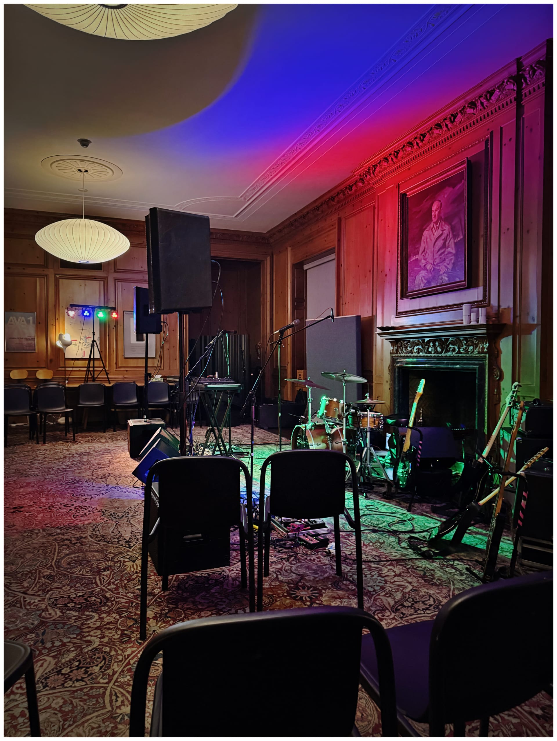 Hanes House venue for a concert. The sitting room in a mansion setup for a band with chairs around them.